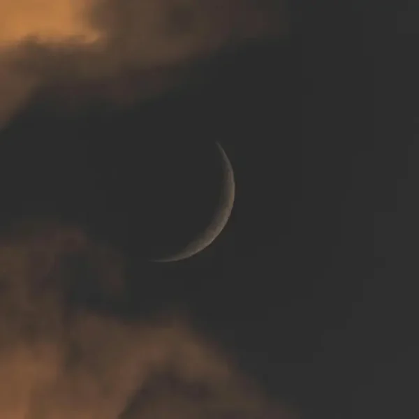 Newmoon amidst dark clouds